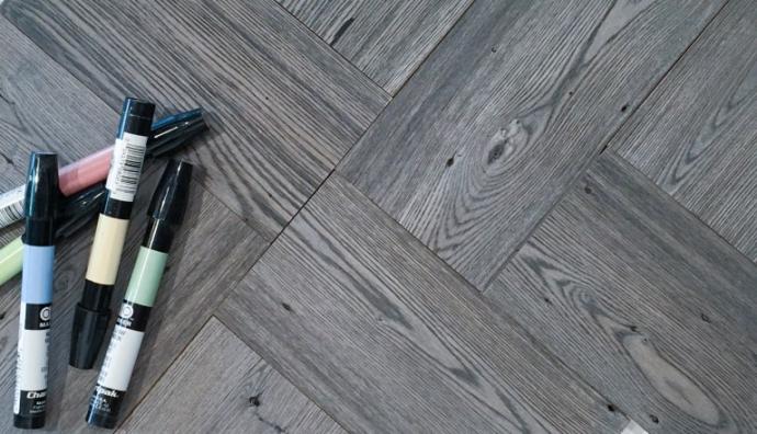 The Grey finish on American Gothic Reclaimed Ash installed in an intricate pattern enhances the swirling grain, knots, insect marks, and other signs of the wood’s previous life.