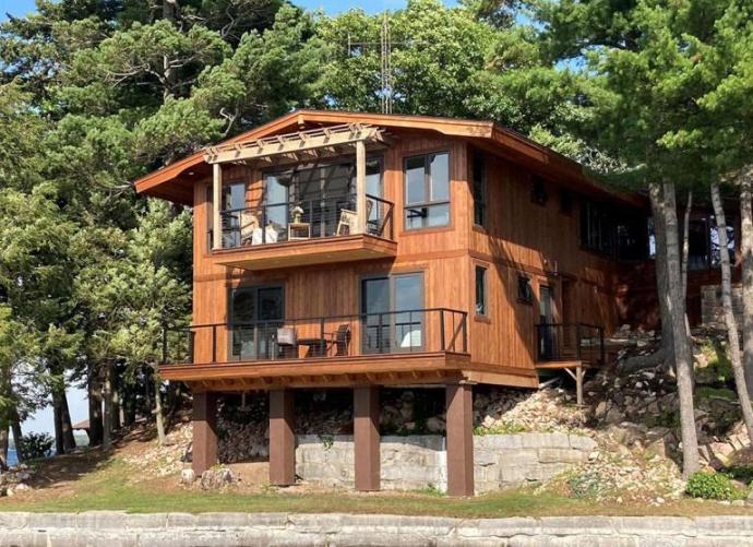 Pioneer Millworks Exterior Select Larch Siding, in light brown, on a lake-side home in New York.