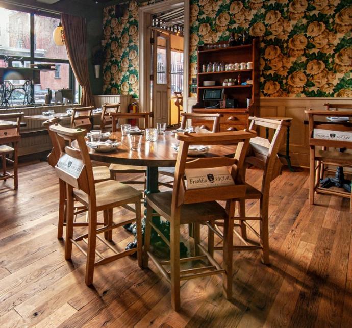 “Bible” inspired chairs provide a place for a quarterly newsletter based on Ben Franklin’s Pennsylvania Gazette, cocktail menus including the 13 Virtues program, and seasonal menus. Underfoot is our Black & Tan–Tan reclaimed oak flooring.