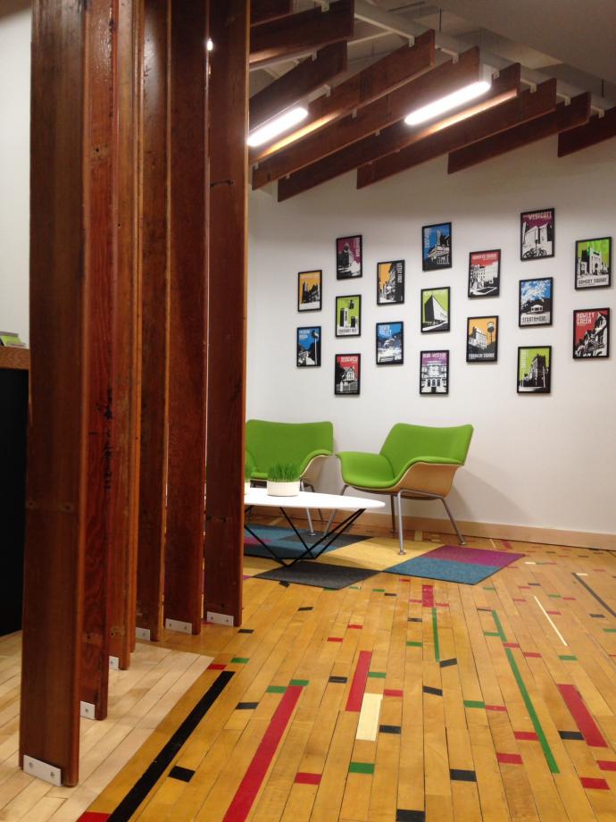 Original gym flooring with reclaimed bleacher boards add character to the Ashley McGraw office in Syracuse, NY.