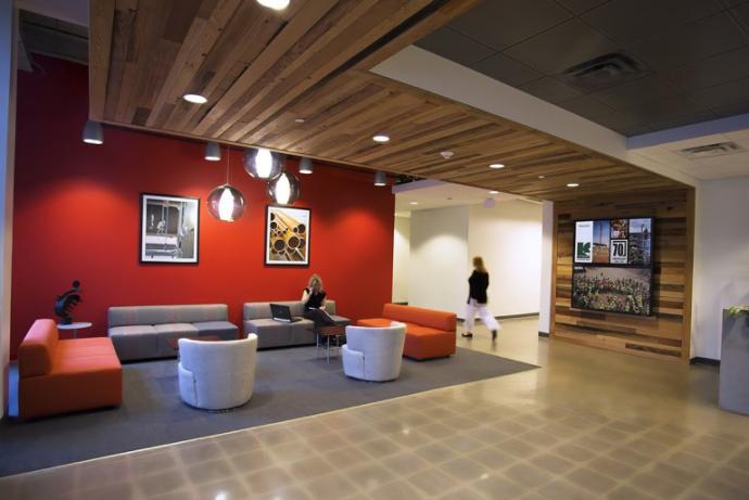 Custom mixed Vat Stock softwoods flow from ceiling to wall in an office waiting area.