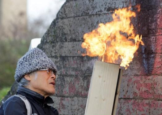 Terunobu Fujimori making shou sugi ban the old fashioned way, with three boards tied into a triangular “chimney.” Nakamura and Fujimori are largely responsible for making this product known to the West.  Photo by https://www.architecture-exhibitions.com  Pioneer Millworks has long made s