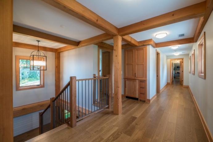 The custom finished Clean White Oak flooring in the upper-level hallway streams into the guest bedrooms and bunk room. Photo (C) Scott Hemenway