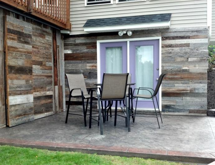 The completed patio is a dramatic change- the siding and fun punch of color on the doors make a huge difference. Now the space is modern and inviting.