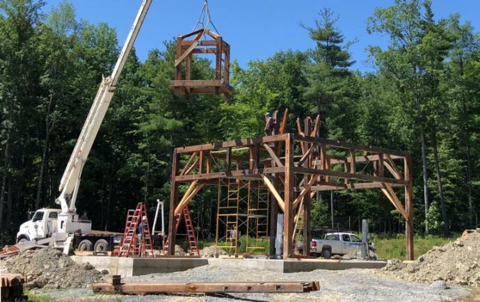 New Energy Works timber framers re-raised the frame, the 3rd use of the reclaimed Welland Canal Douglas fir timbers, to form Point of the Bluff Vineyards event space overlooking Keuka Lake.