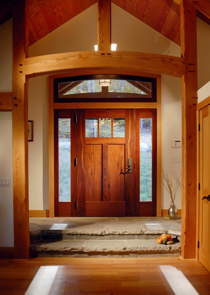 Nestled in the Adirondacks, this custom timber frame home features a reclaimed Jarrah entry door and sidelights.