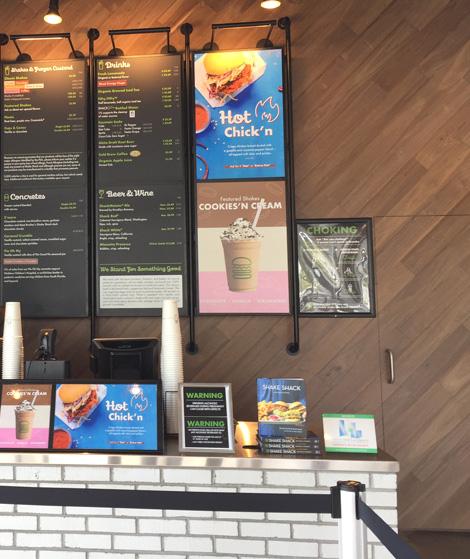 Modern Farmhouse Clean Walnut installed at an angle by Bay Meadow’s team on several walls of a Florida burger shop.