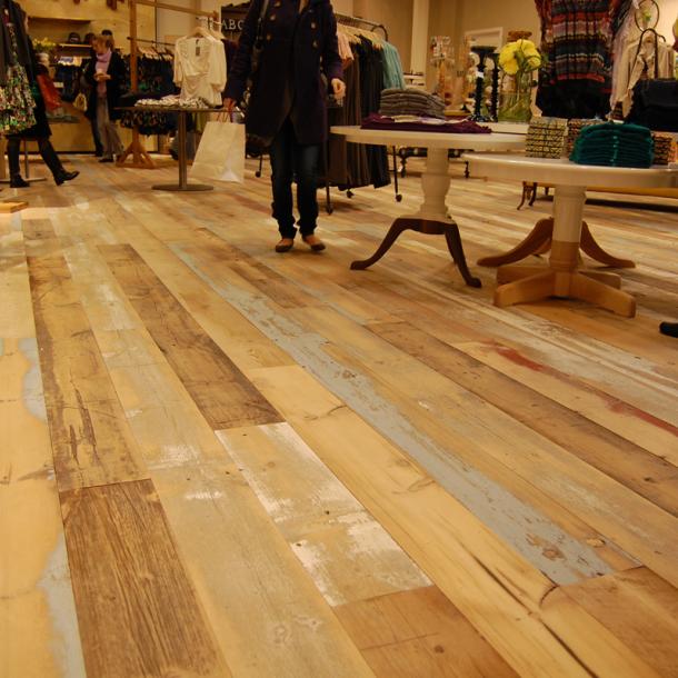A custom mixture of American Prairie reclaimed softwoods (barn wood) was gently planed to keep some of the paint intact for this custom wide plank floor.