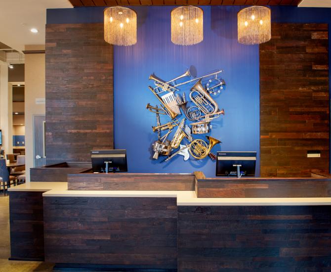 Reclaimed Teak with a custom finish wraps around the hotel lobby front desk area