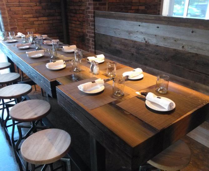 Reclaimed from a canal lock, tha massive reclaimed Douglas fir timber was sawn into slabs to from community tables at TRATA in Rochester, NY.