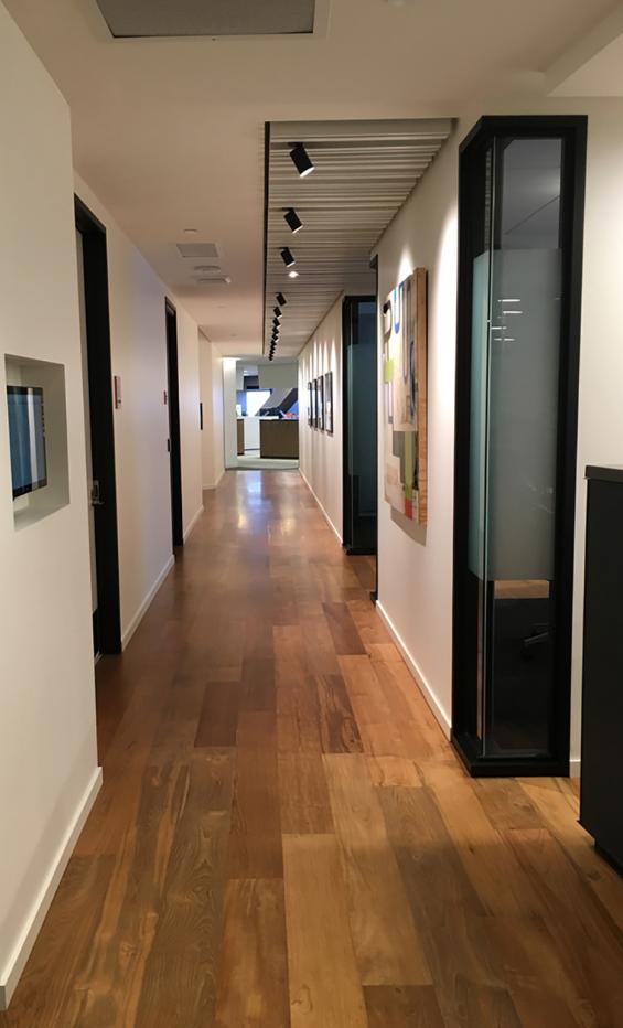 Reclaimed Teak wood flooring flows down this office hallway in Seattle, WA