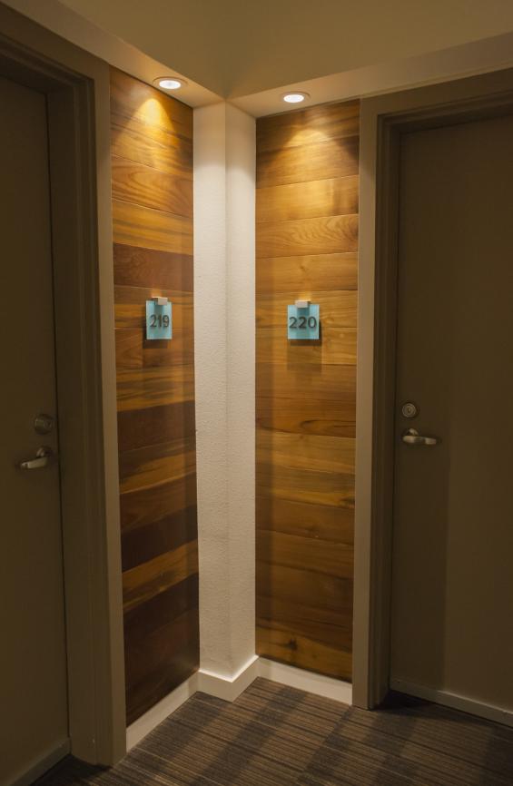 Reclaimed Teak used as wall paneling around apartment entryways 