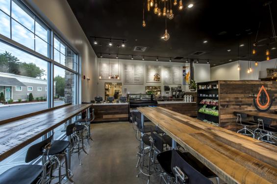 Reclaimed mixed hardwoods form tables and paneling within Pressed Cafe.