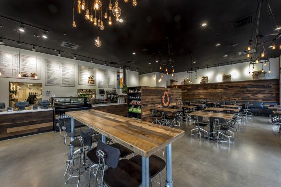 Custom tables and a CNC logo were crafted by NEWwoodworks for this cafe.