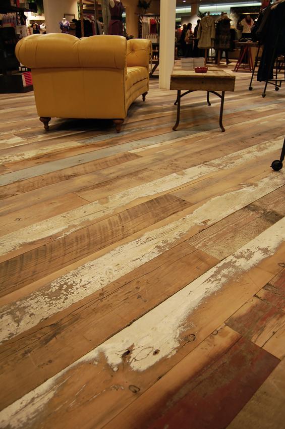 A custom mixture of American Prairie reclaimed softwoods (barn wood) was gently planed to keep some of the paint intact for this custom wide plank floor.