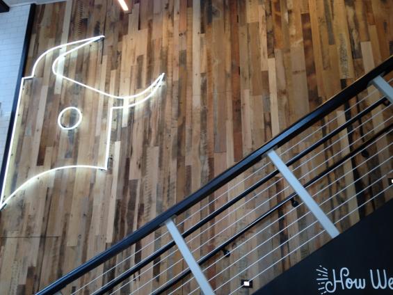 Close up of the Settlers' Plank Mixed Hardwoods wall paneling with the Dos Toros bull logo lit up.