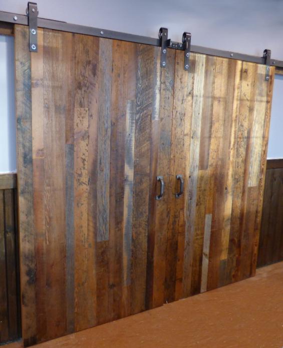 Double doors of reclaimed mixed hardwoods divide a party room from the main dining area at a New York bar/grill.