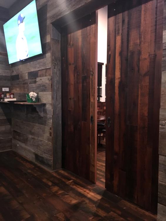 A custom flat track door is used to separate dining areas in Jeremiah's in Henrietta, NY.