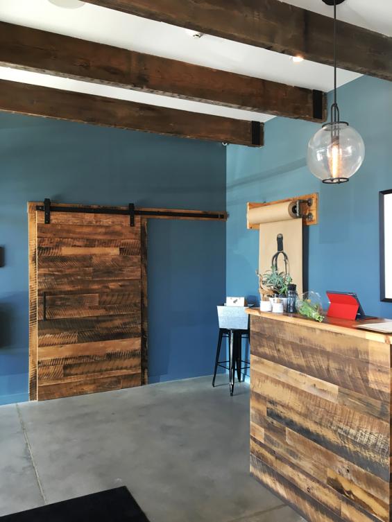 A flat track door and hostess station were made with Settlers' Plank reclaimed hardwoods by NEWwoodworks.