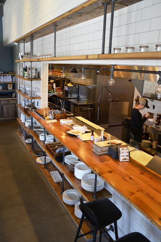 Reclaimed thresher boards form the kitchen-side counter top seating centered between matching shelving from NEWwoodworks.