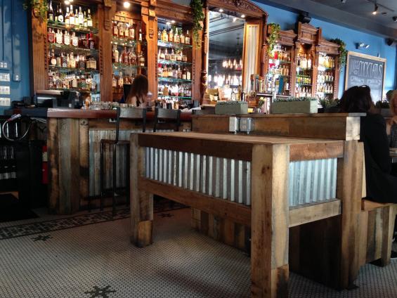 The server station and bar front of Mexicue in New York City are clad with Settlers' Plank Mixed Oak reclaimed wood paneling 