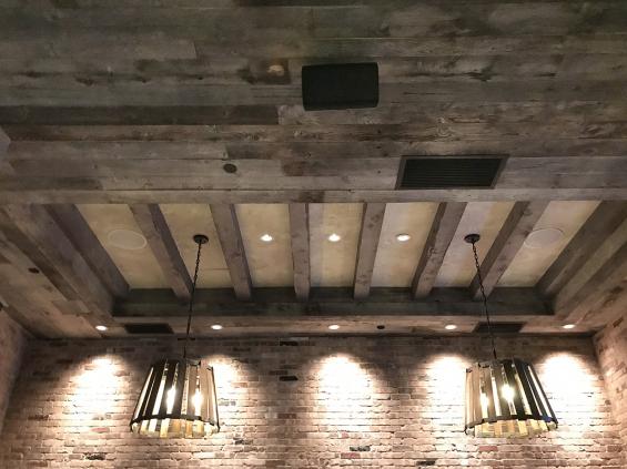 American Prairie Corral Board paneling above the light fixtures of this Boston bar completes the look.