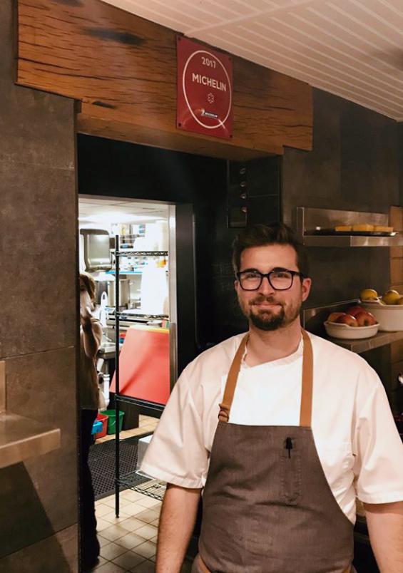 James Beard award-winning Chef Jeremiah stands in front of The Dabney's Michelin star mounted on American Gothic White Oak reclaimed wood.