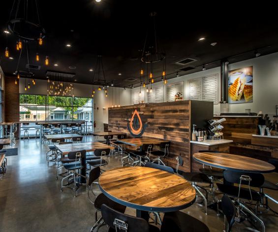 Inlayed within a wall of reclaimed mixed Settlers Plank hardwoods, the Pressed Cafe orange and black logo serves as focal point and separation of the ordering area from the dining space.