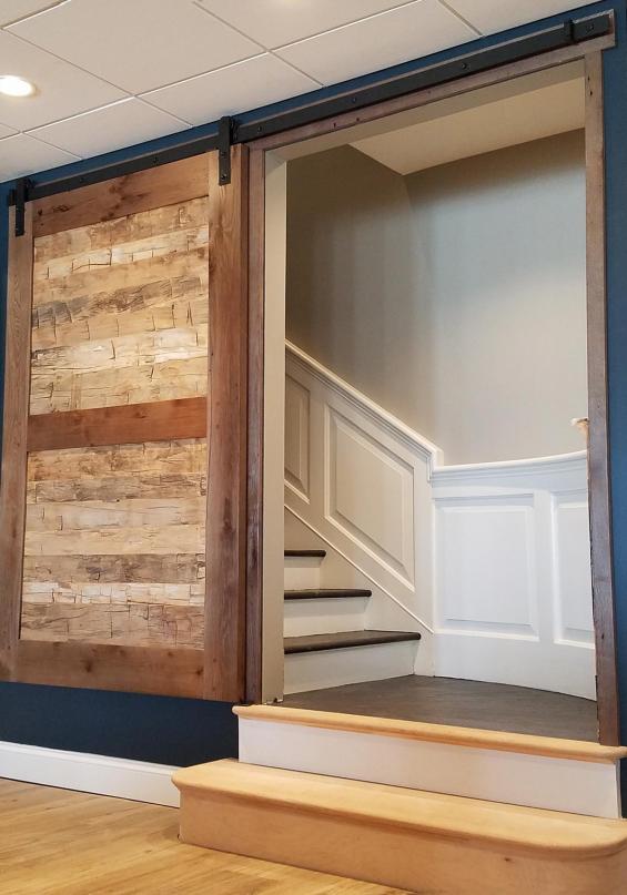 Reclaimed Wood Flat Track Door with American Gothic Oak frame with a custom finish and as-found hand-hewn panels.