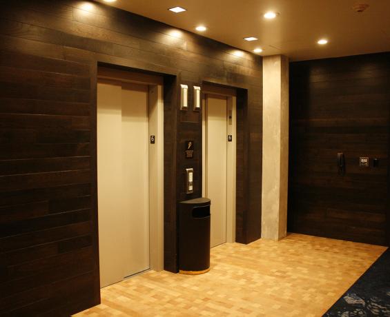 Reclaimed Mixed Oak wall paneling with a custom stain surrounds the elevators at the Hi-Lo Hotel in Portland, OR.