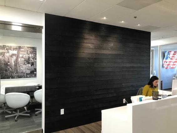 Shou Sugi Ban Larch Deep Char by Pioneer Millworks. Black wood siding that is burned. Here seen as interior paneling at a private office.