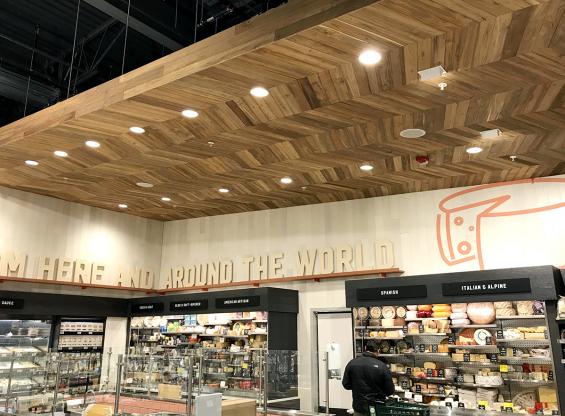 Bright Indonesian Teak is used for the chevron patterned ceiling. All wood is finished with a penetrating fire retardant, and white planks are Modern Farmhouse Clean White Oak paneling with a custom tinted finish