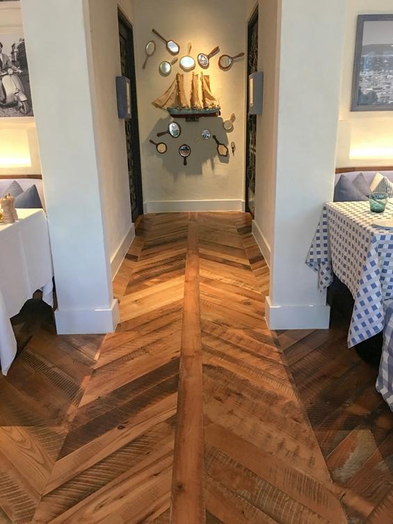 Pioneer Millworks reclaimed Settlers' Plank Mixed Hardwoods in Dolce Riviera restaurant in Dallas, Texas. Installed in a chevron pattern.