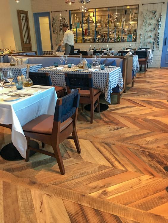 Pioneer Millworks reclaimed Settlers' Plank Mixed Hardwoods in Dolce Riviera restaurant in Dallas, Texas. Installed in a chevron pattern.