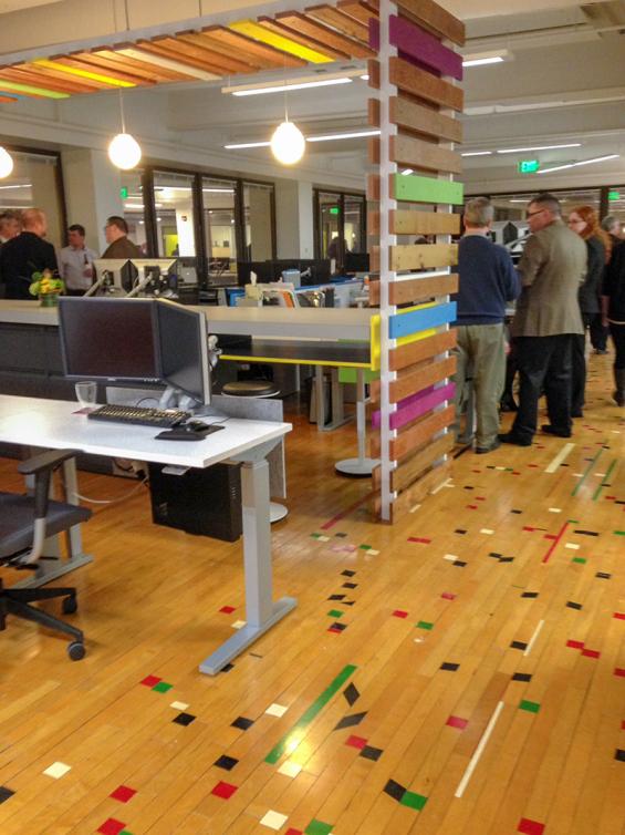 Pioneer Millworks reclaimed gym flooring in a confetti pattern with reclaimed mixed Oak, Black & Tan—Tan slat wall.